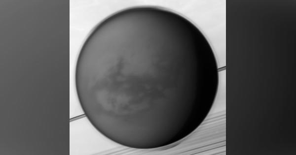 土星の手前に浮かぶ衛星タイタン。土星探査機「カッシーニ」が撮影