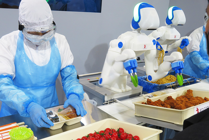 人とロボットが並んで作業、食品工場に新スタイル