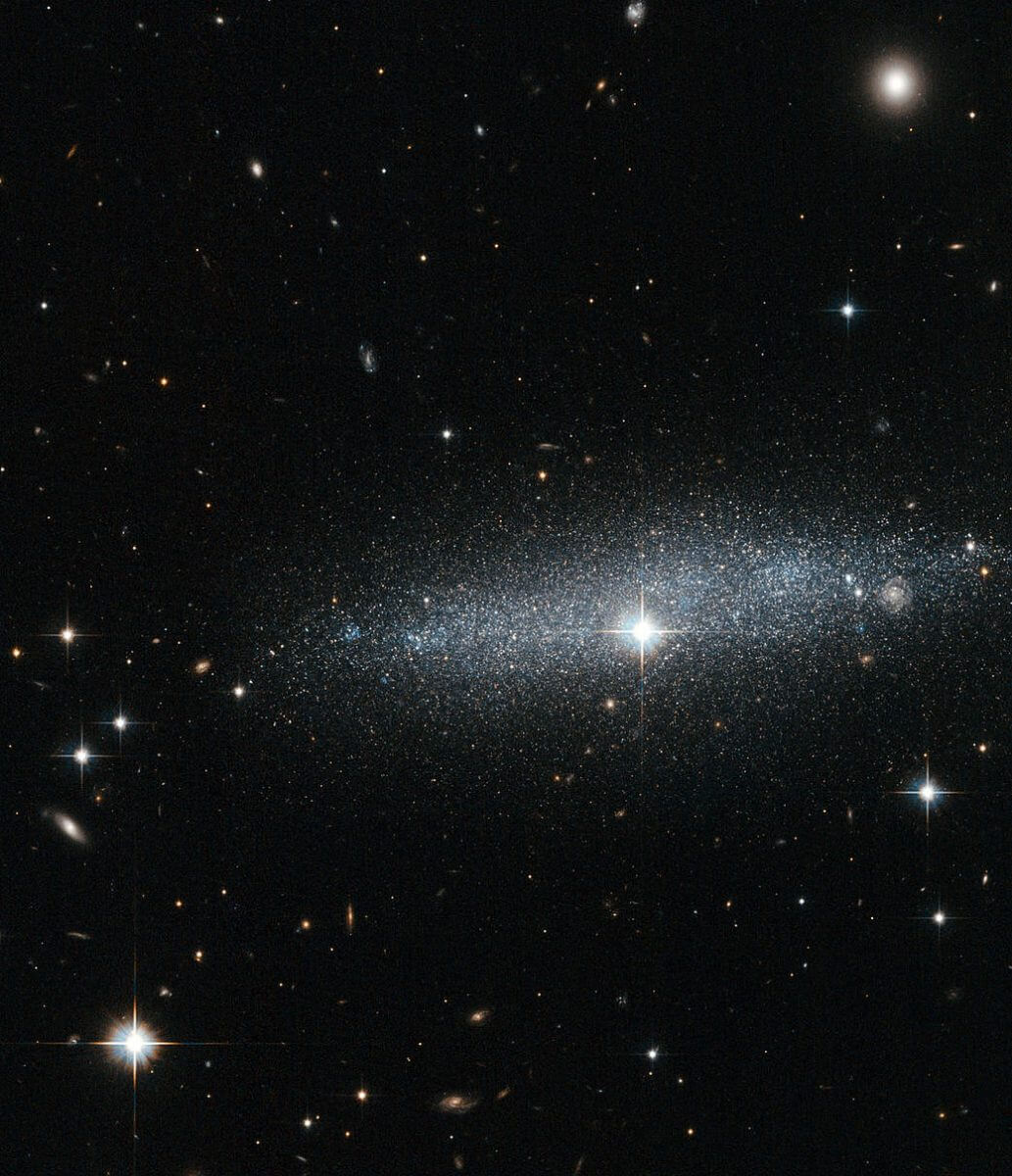 キラキラ銀河のスカスカな空間を透して見る渦巻銀河