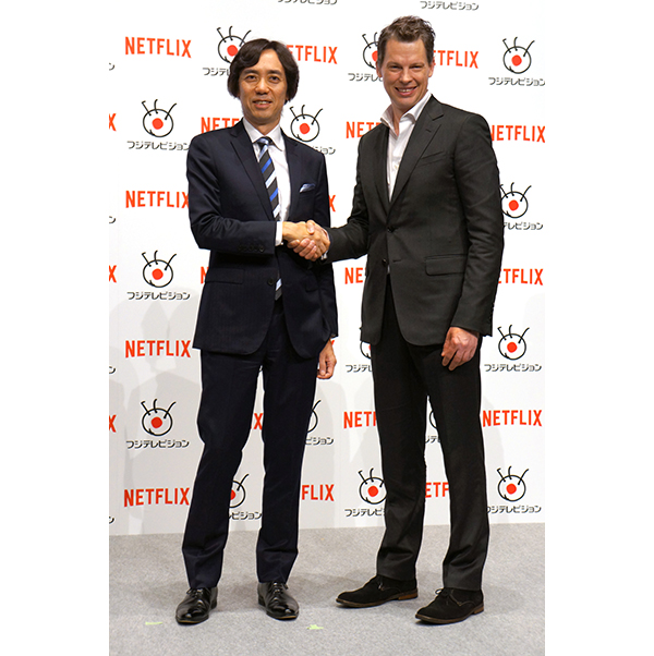 握手するフジテレビ大多亮常務（左）とネットフリックス日本法人のグレッグ・ピーターズ代表（右）